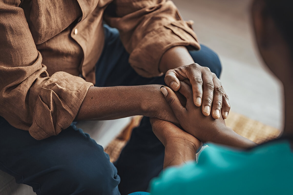 A man and a disabled woman locked hands in support and reassurance.