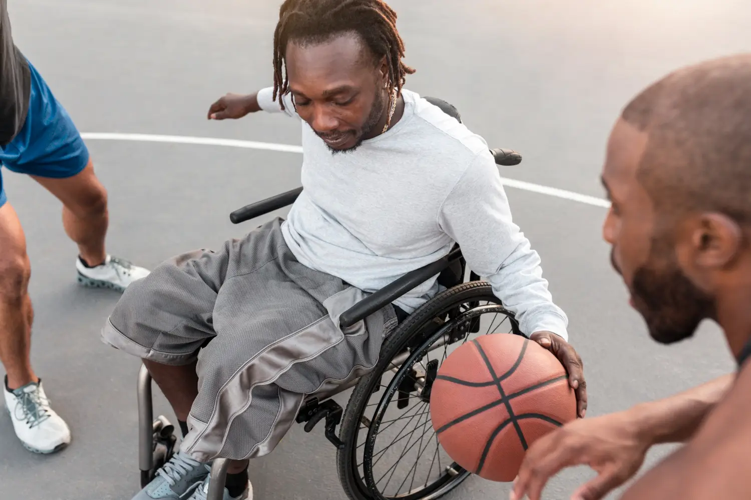 A disabled man wheelchair playing basketball with his friends