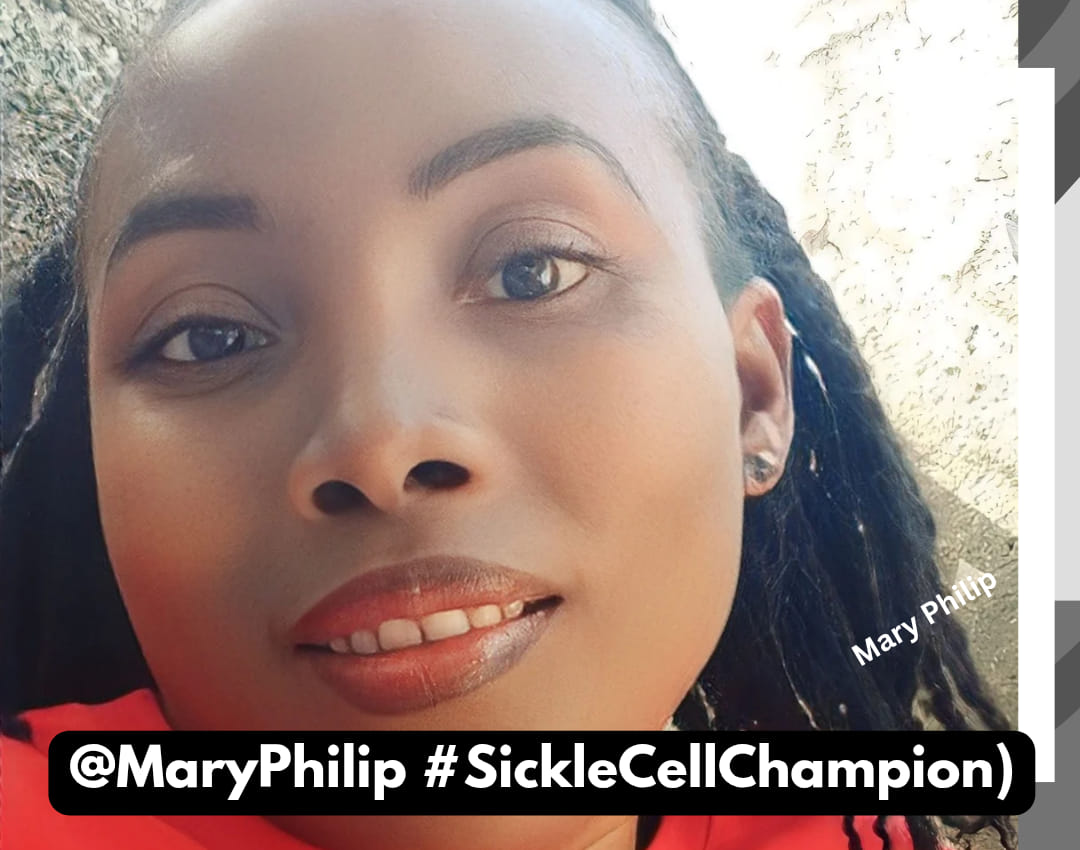 Close-up photo of Mary Philip  with dark braided hair, smooth skin, and natural makeup. She has a gentle smile showing her teeth and is wearing earrings. The background is outdoors with sunlight and a rough-textured wall. The text in the image reads “Mary Philip” in white near her hair, and at the bottom in a black banner, it says “@MaryPhilip #SickleCellChampion)”.